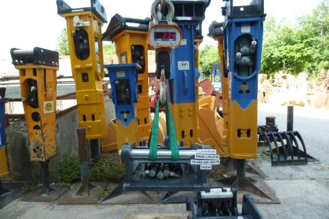 SW-Adapterplatte SW 48 Likufix ART-271-099 – Weitwinkel-Aufnahme im Lagerhof, Adapterplatte hängt am Kranhaken mit Kranwaage zwischen weiteren Hydraulikhämmern