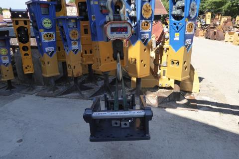 SW-Adapterplatte SW 48 Likufix ART-271-101 – Übersichtsaufnahme im Lagerhof, an Kranwaage hängend zwischen weiteren Hydraulikhämmern