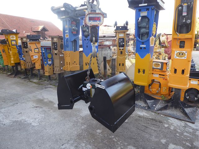 2-Schalen-Hydraulik-Greifer ART-274-001 – Kranwaage zeigt 162 kg, Lagerreihe mit Hydraulikhämmern im Hintergrund