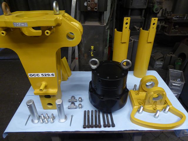 Liebherr GM 10 – Werkstatt, sämtliche Einzelteile inkl. Rotator und Zylinderrohre auf Werktisch